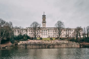 a large building with a clock tower next to a body of water